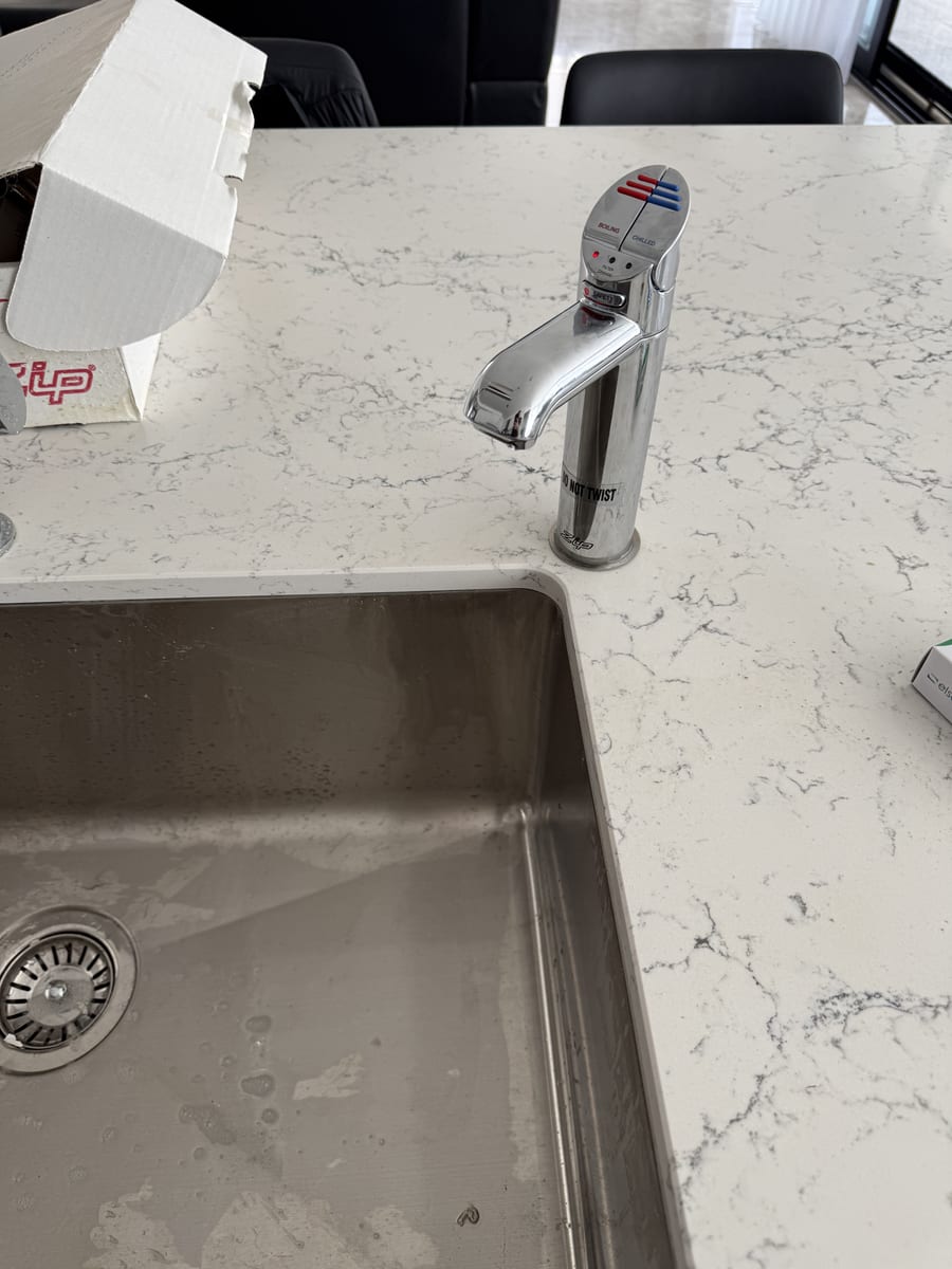 New kitchen sink and mixer tap installed in a stone benchtop